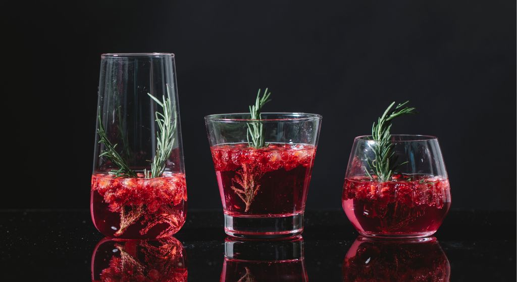 Red Christmas cocktails with rosemary twigs