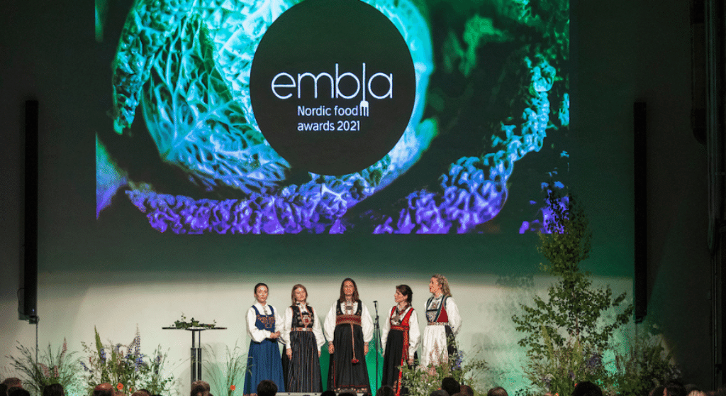 Women dressed in traditional Nordic folk costumes on the stage at EMBLA Nordic Food Awards.