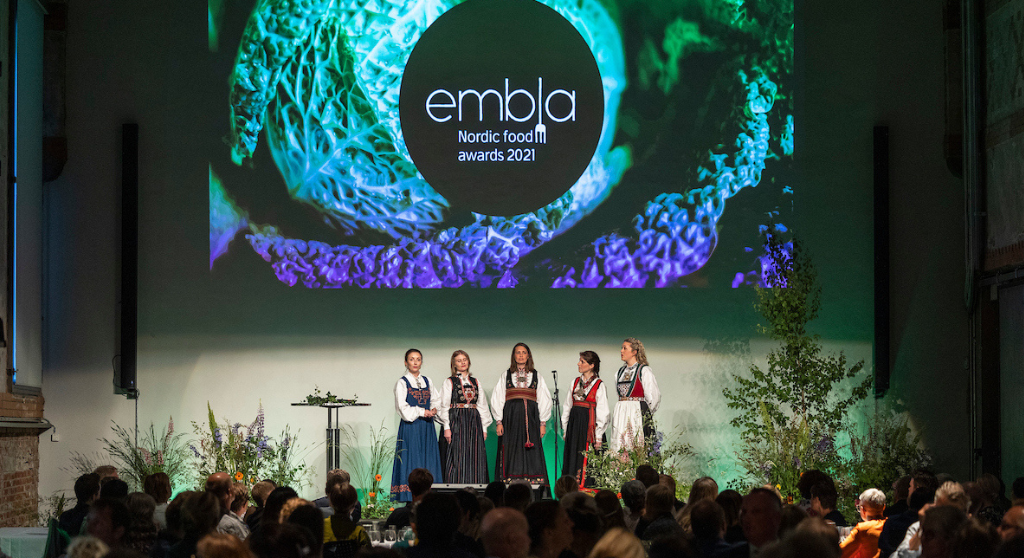 Women dressed in traditional Nordic folk costumes on the stage at EMBLA Nordic Food Awards. 